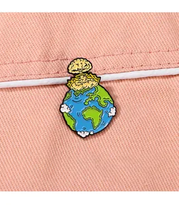 Détail macro du pin's en émail forme Terre avec champignon atomique sur tissu