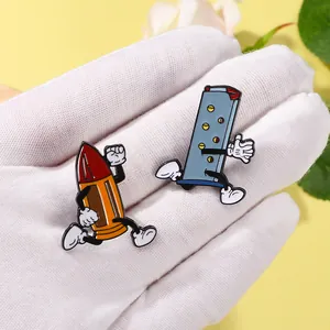 Detail of cartoon bullet and magazine enamel pins on a person's gloved hand