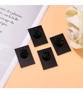 Detail of matte black floral stamp brooch back with textured surface and butterfly clutch