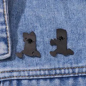 Black metal enamel pin backings with textured finish on blue denim jacket fabric