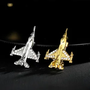 Macro des broches d'avion argentées et dorées avec strass blancs étincelants