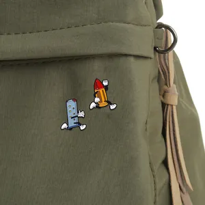 Detailed close-up of cartoon enamel pins featuring a magazine and bullet on canvas strap