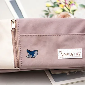 Detail van canvas etui met Simple Life label en een blauwe walvis emaille speldje