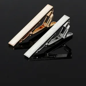 Detail view of gold and silver tie clips with iridescent white shell inlay for men