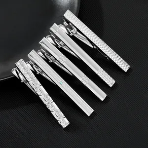Detailed set of five silver metal tie clips with various textured patterns and engravings