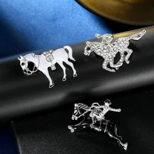 Close-up of three equestrian horse brooches with enamel and rhinestones on black leather