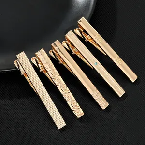 Macro shot of gold tie clips for men with diamond patterns and blue rhinestone inlay