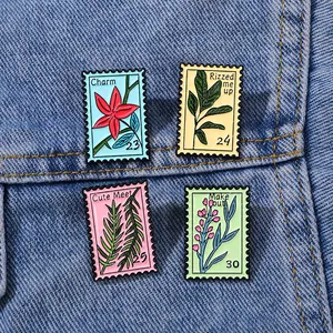Floral enamel stamp pins with botanical motifs on denim background for fashion accessories