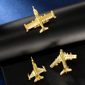 Détail macro de trois broches d'avion plaquées or avec des strass étincelants incrustés