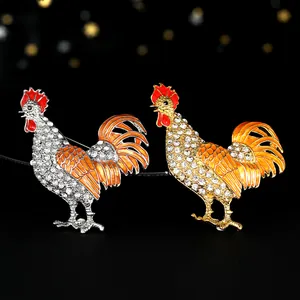 Dettaglio di spille a forma di gallo in argento e oro con cristalli e smalto colorato