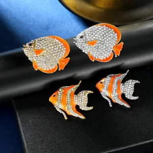 Macro detail of high-end orange enamel tropical fish brooches with crystal rhinestones