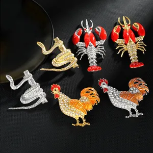 Vista dettagliata di spille animali in smalto con motivi di gallo e aragosta e strass