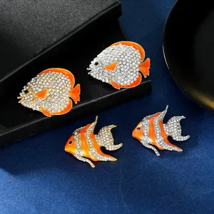 Elegant gold-tone tropical fish brooches with orange enamel and sparkling rhinestones