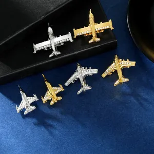 Détail de broches en forme d'avion dorées et argentées serties de strass sur velours