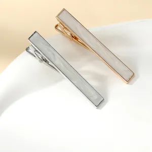 Detail view of premium business tie clips with white shell inlay in gold and silver finish