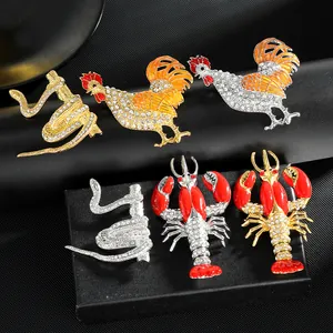 Dettaglio macro di spille animali in lega con strass scintillanti e smalto colorato