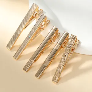 Detailed close-up of five elegant gold-plated tie clips with varied textured designs