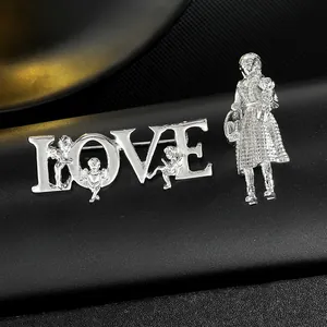 Makroaufnahme der silbernen LOVE-Brosche mit Amor und Mädchen-Anstecker auf Leder