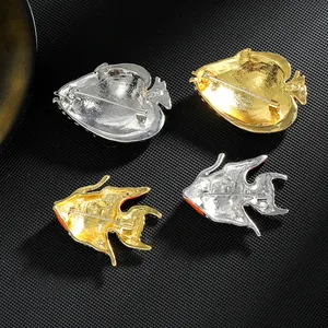 Set of four fish brooches in gold and silver finish with detailed pin backs