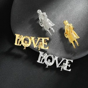 Detaillierte Nahaufnahme von gold- und silbernen LOVE-Broschen mit Amor auf schwarzem Grund