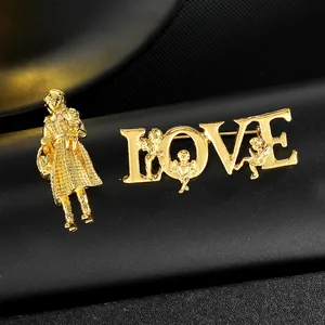Goldene Broschen mit Mädchen und LOVE-Schriftzug mit Engeln auf schwarzem Hintergrund