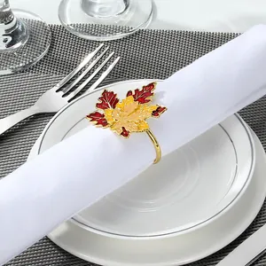 Detailed close-up of a gradient maple leaf napkin ring with golden plating on a dining plate