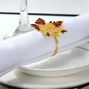 Detailed view of an autumn maple leaf napkin ring with red and orange enamel and gold band