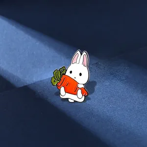 Cute white cartoon bunny rabbit enamel brooch holding a carrot on a blue podium