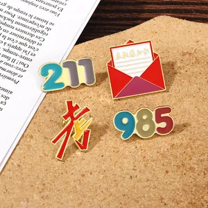 Detail view of 985 and 211 enamel pins with university admission envelope on cork board