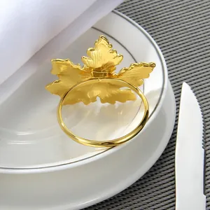 Elegant gold leaf napkin ring on a white plate with a festive dining setup