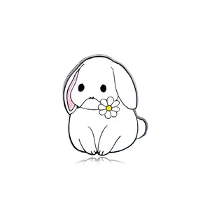 Detailed close-up of a white rabbit enamel pin with a daisy flower and black metal edges