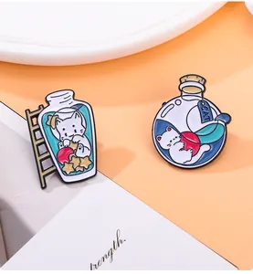 Détails de deux épingles en émail de chats mignons dans des bouteilles en verre