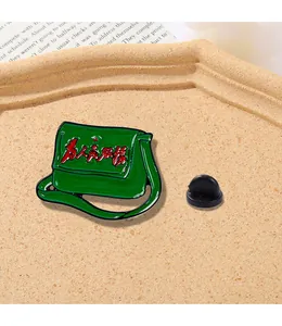 Detailed close-up of a vintage green satchel enamel pin with red Chinese calligraphy