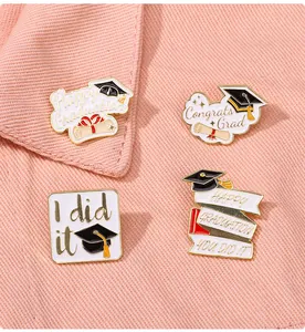 Detail of Graduation pins with 'Happy Graduation' and 'Congrats Grad' on pink denim background