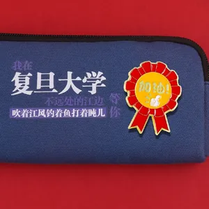 Rote Emaille-Plakette mit Daumen-hoch-Design an einer dunkelblauen Schulmäppchen