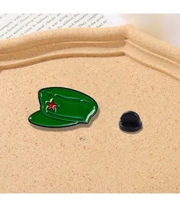Detailed view of green military cap enamel pin with a red star and black rubber clutch