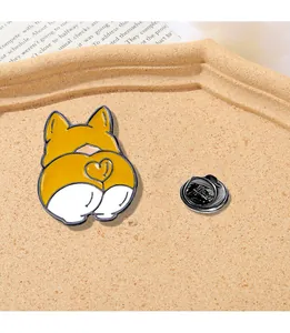 Detailed view of enamel corgi butt pin with heart pattern on beige tray