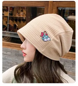 Détail d'un écusson chat mignon sur un bonnet en tricot beige pour femmes