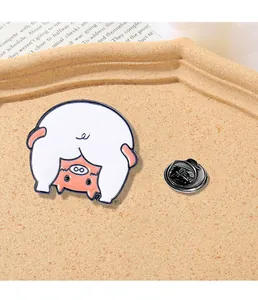 Close-up of a funny cartoon pig enamel pin with a metal clutch on cork background