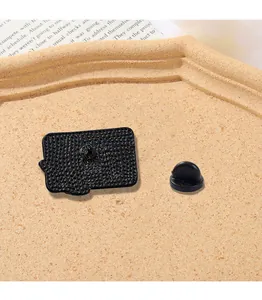 Close-up of enamel pin back with black textured finish and rubber clutch fastener