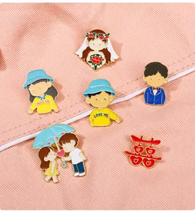 Detail of colorful enamel wedding brooches on pink fabric showing diverse cute characters