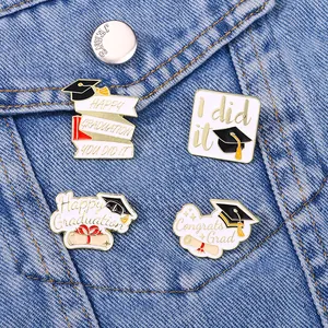 Enamel graduation cap pins set on denim jacket featuring happy graduation lettering