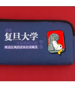 Close-up of enamel white cat badge on dark blue canvas bag with Fudan University theme