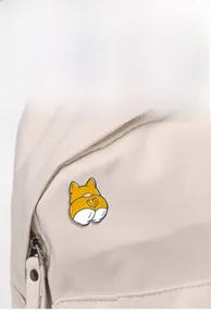 Detail of cute Corgi butt enamel pin with red heart on a beige canvas tote bag