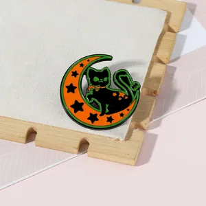 Détail du pin's d'Halloween avec chat noir assis sur un croissant de lune orange