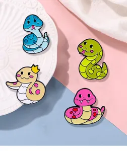 Détail de quatre épingles en émail de serpent de dessin animé sur assiette décorative