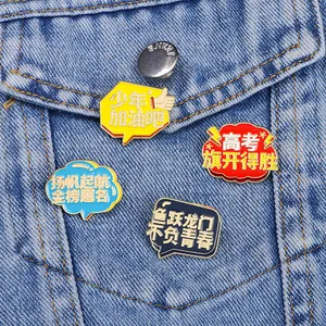 Set di quattro spille smaltate colorate con testo motivazionale cinese su sfondo denim