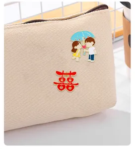 Detail of cartoon enamel pins and Double Happiness badge pinned on canvas bag