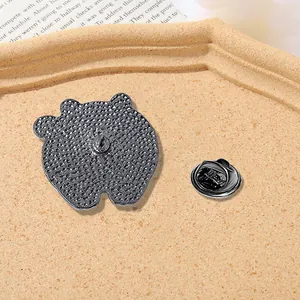 Apple shaped enamel pin back view featuring textured metal and black butterfly clutch