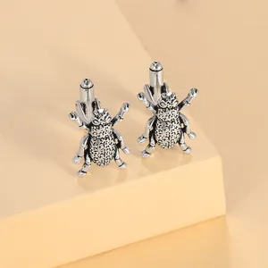 Macro shot of vintage silver beetle cufflinks with intricate mesh texture and 3D legs
